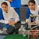 Members of the Afghan all-girls robotics team, with their robot nearby, watch the robots of other countries in the practice area on July 17, 2017 in Washington, D.C.